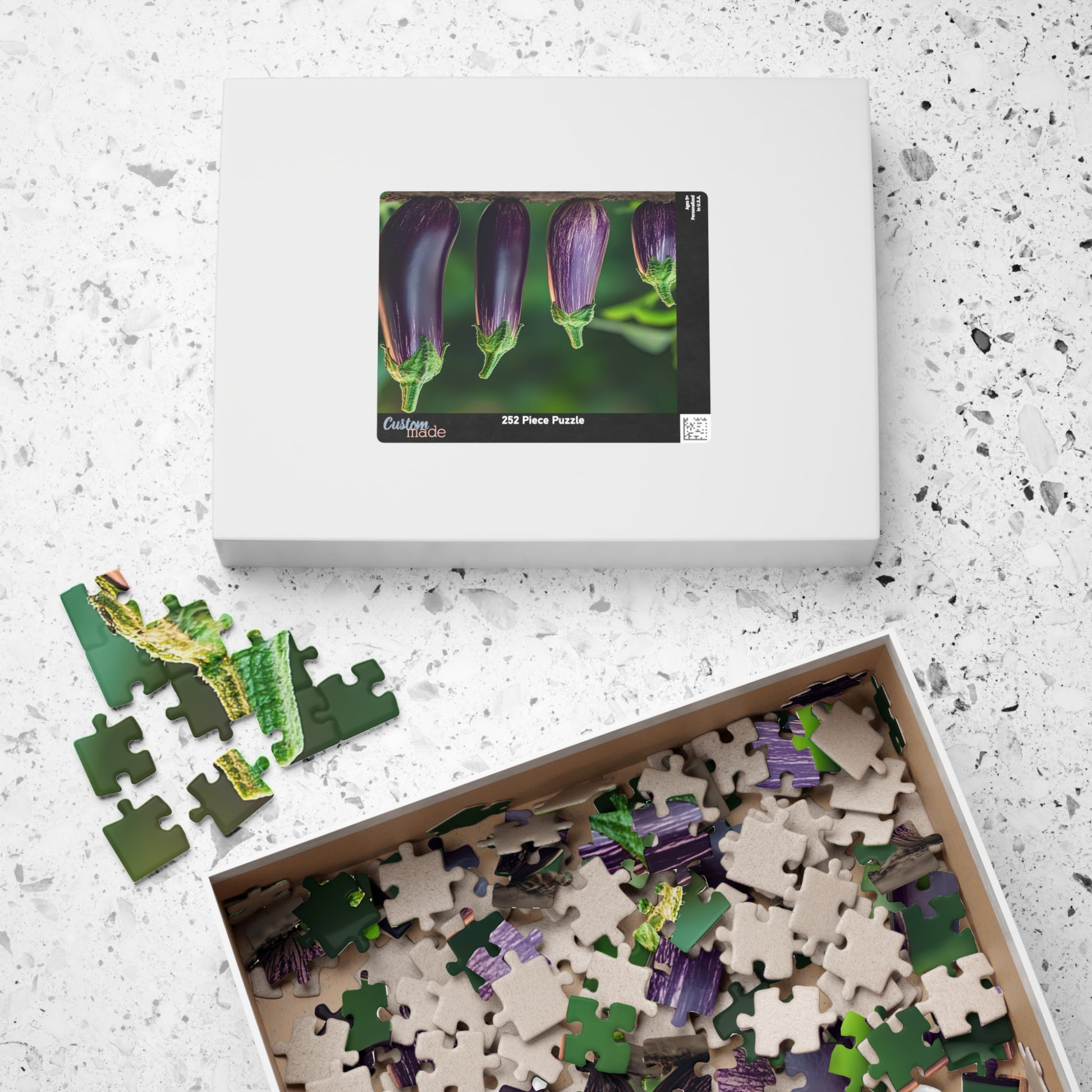 Jigsaw puzzle set with a box featuring purple flowers on a textured surface